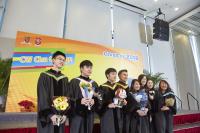 Graduating students in front of the photo backdrop